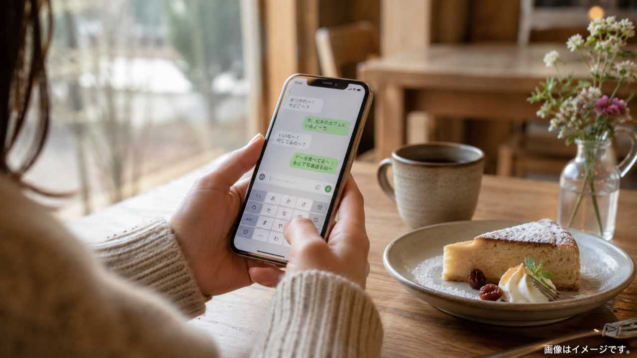 信州のカフェでスマートフォンに短い方言メッセージを入力している手元